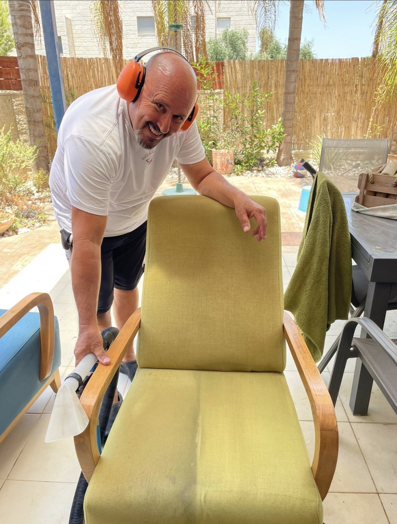 אלמוג בעבודה על כורסה צהובה אצל הלקוח